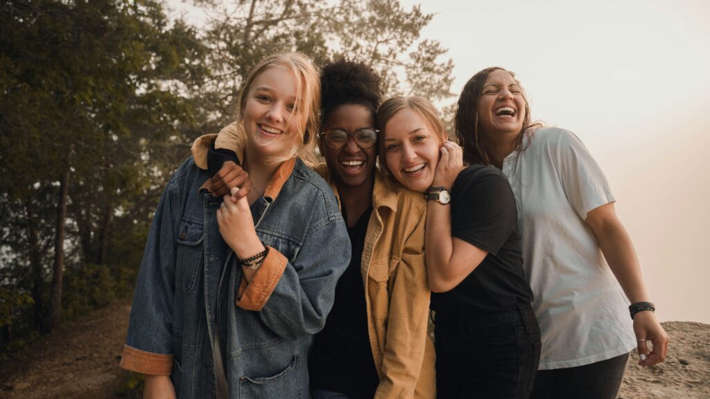 Small group of women embracing and smiling, showing solidarity and empowerment.
